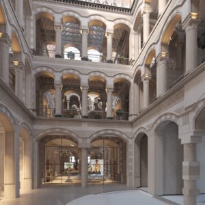 Binnenhof van monumentaal pand aan de Nieuwezijds Voorburgwal met hoge bogen, zuilen en glazen winkelpui.